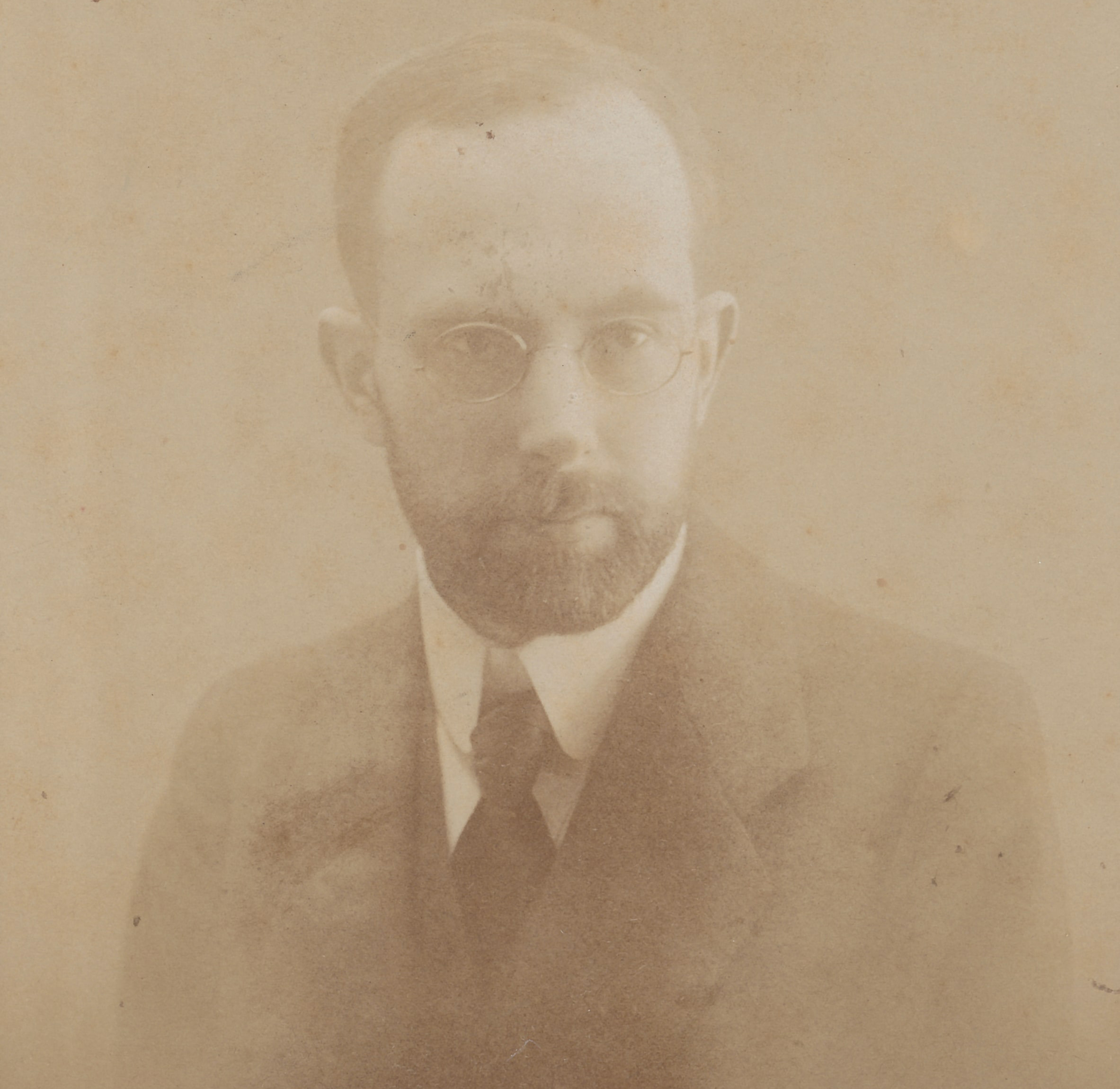 Porträt Paul Goesch. Ein altes Foto in Sepia Tönen. Ein Mann mit Brille und Bart. Er trägt einen Anzug und schaut ernst.